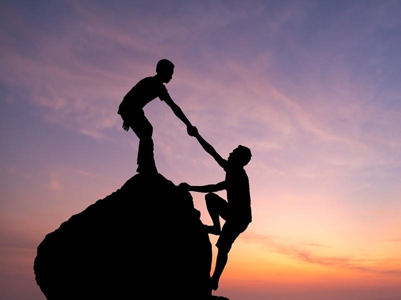 Teamwork couple hiking help each other trust assistance silhouette in mountains, sunset. Teamwork of man to success Teamwork couple hiking help each other trust assistance silhouette in mountains, sunset. Teamwork of man to success